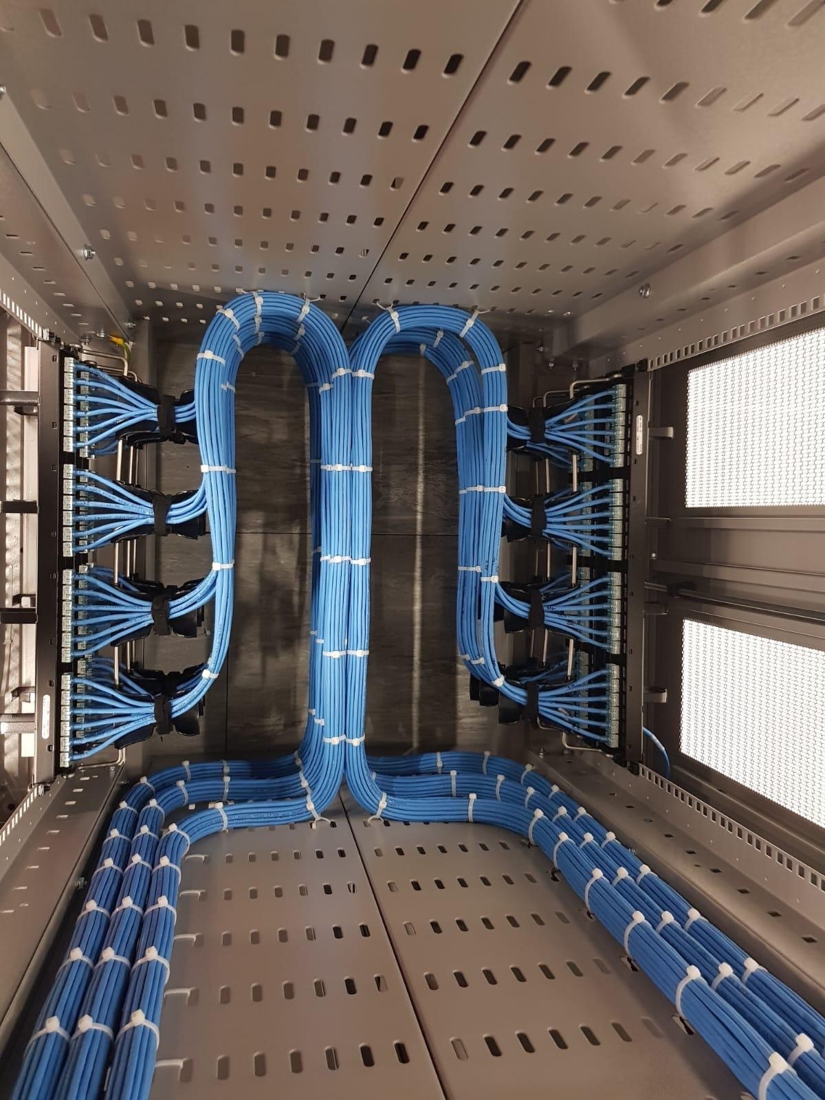 Symmetrical blue structured cabling routed inside a cabinet