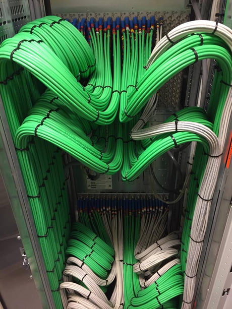 Green and white cable bundles arranged in balanced rack arcs