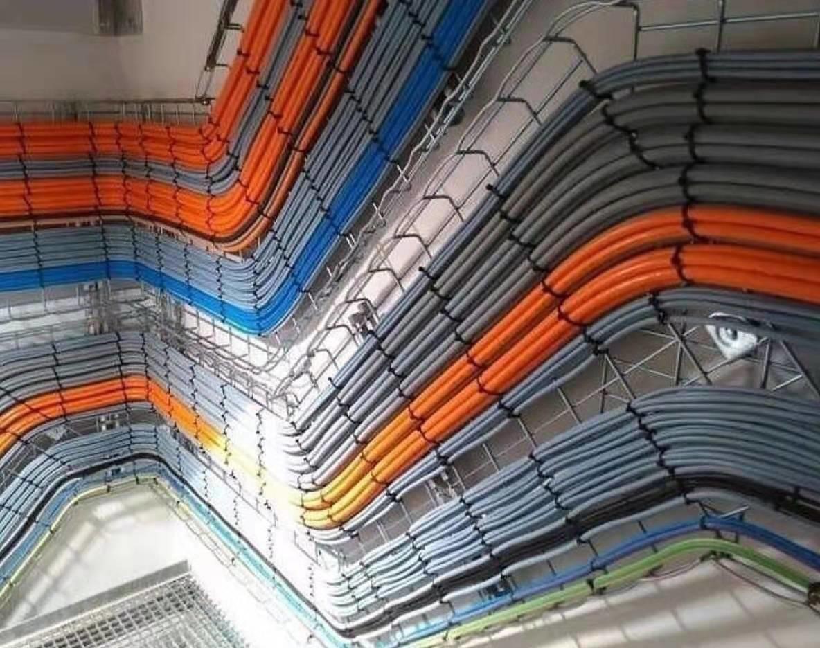 Orange, blue and gray cable bundles sweeping through overhead tray